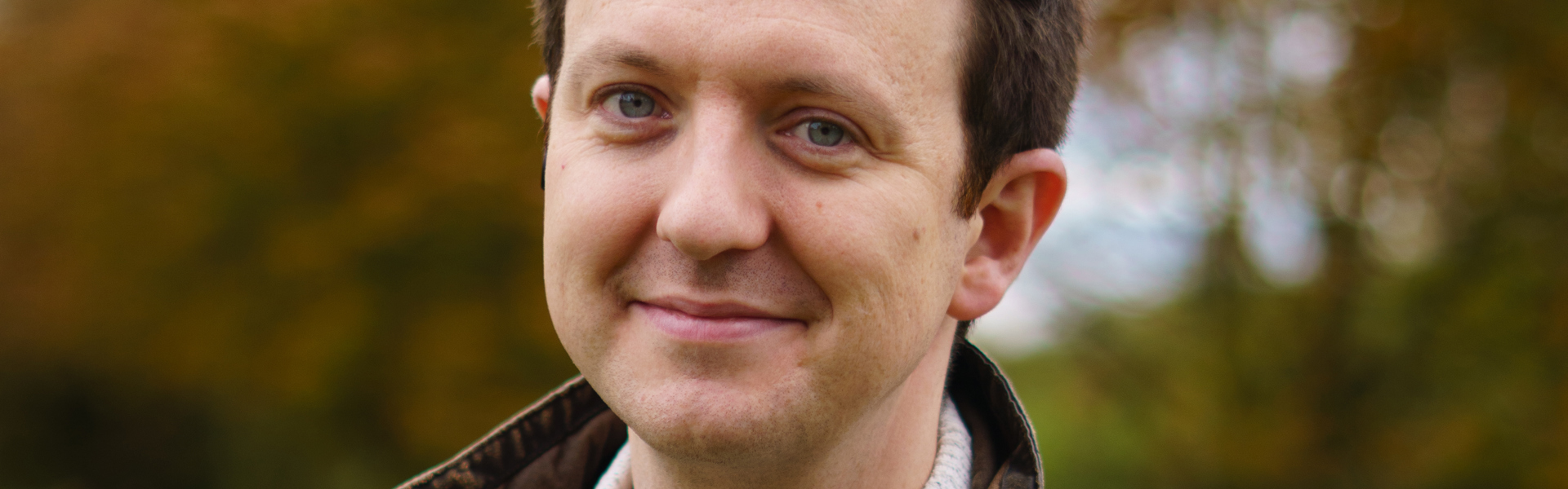Main image: Murder Mystery Author Tom Hindle, stood outside smiling to the camera.