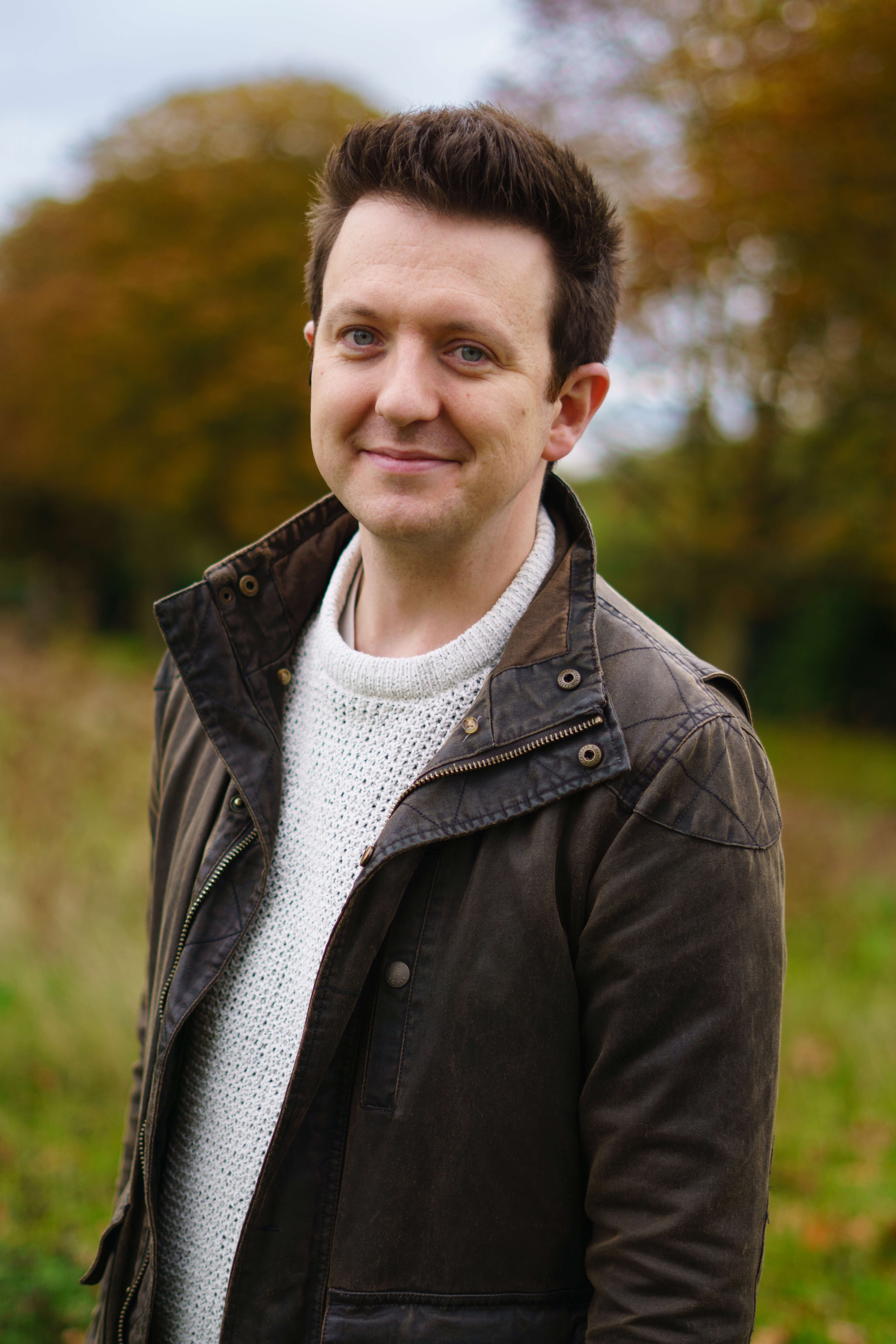 Main image: Murder Mystery Author Tom Hindle, stood outside smiling to the camera.