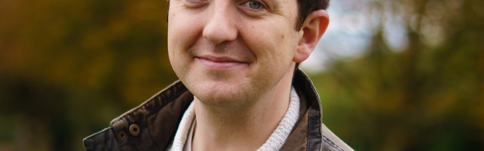 Main image: Murder Mystery Author Tom Hindle, stood outside smiling to the camera.