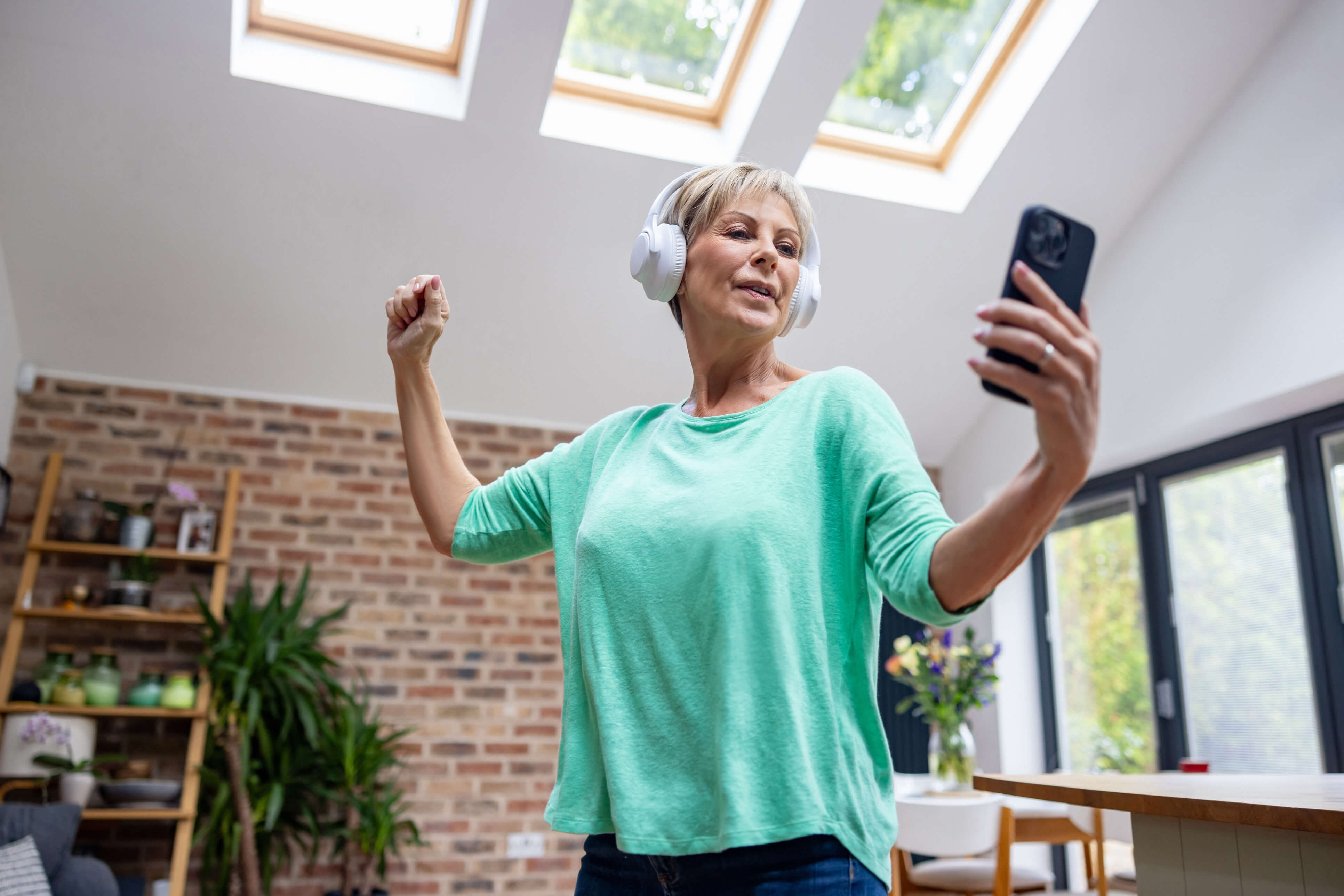 A woman working out at home with class on a mobile phone 