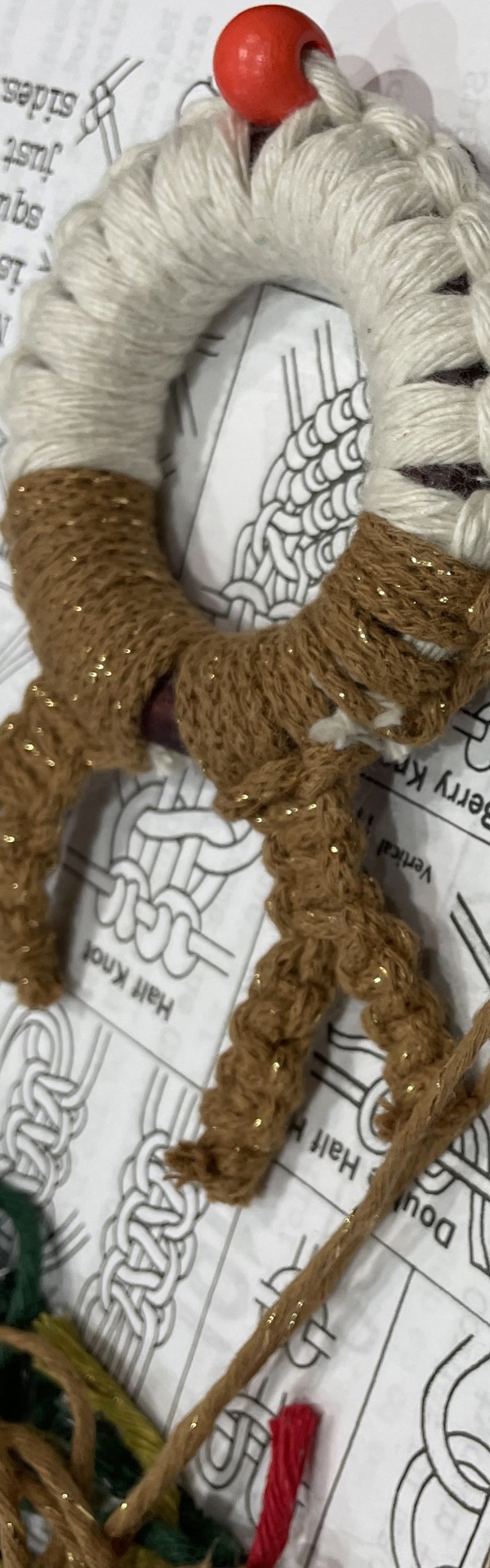 Main image: Macrame wreath reindeer ornament, with brown and white cord, and a red bead nose.