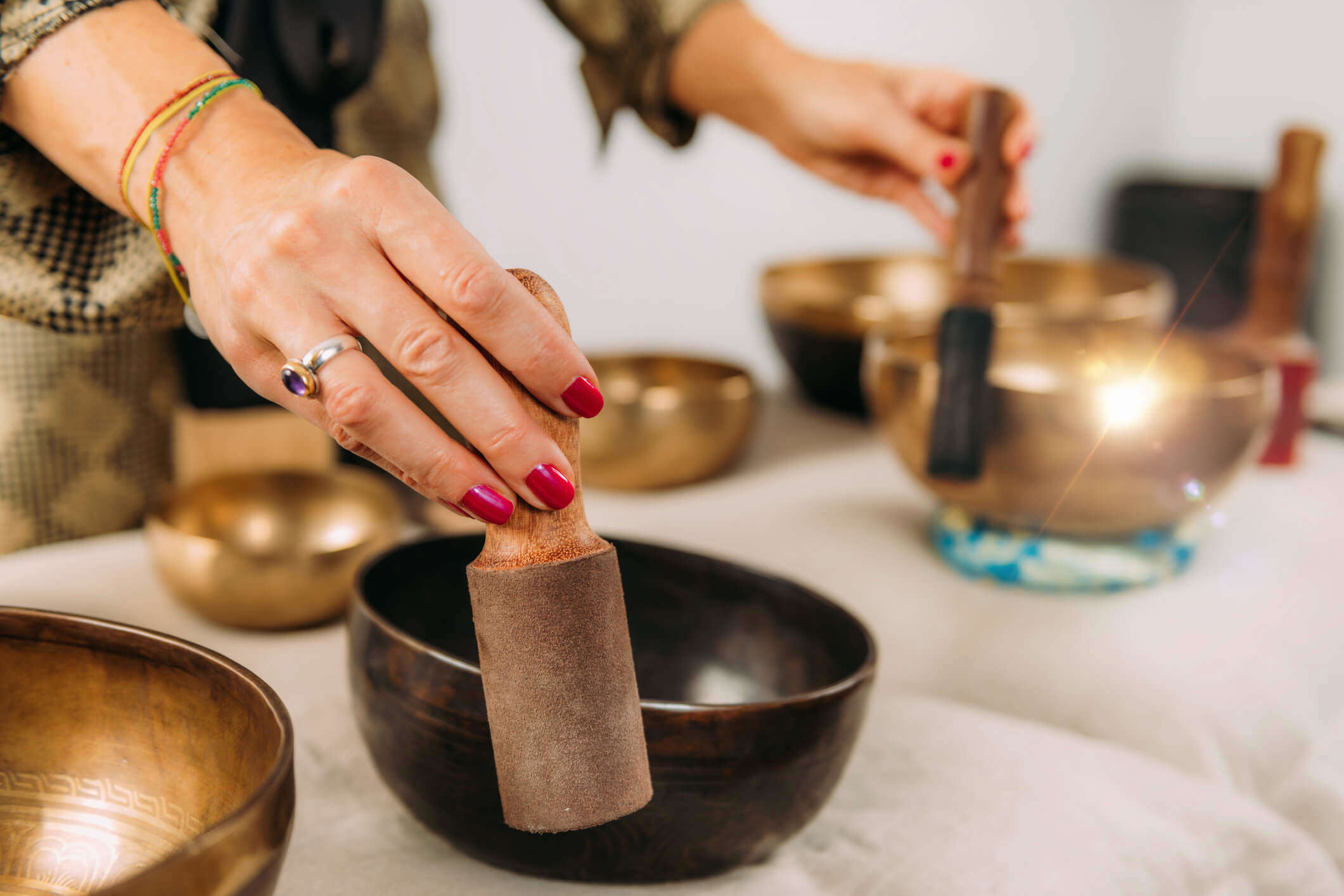 a person playing singing gold and bronze singing bowls