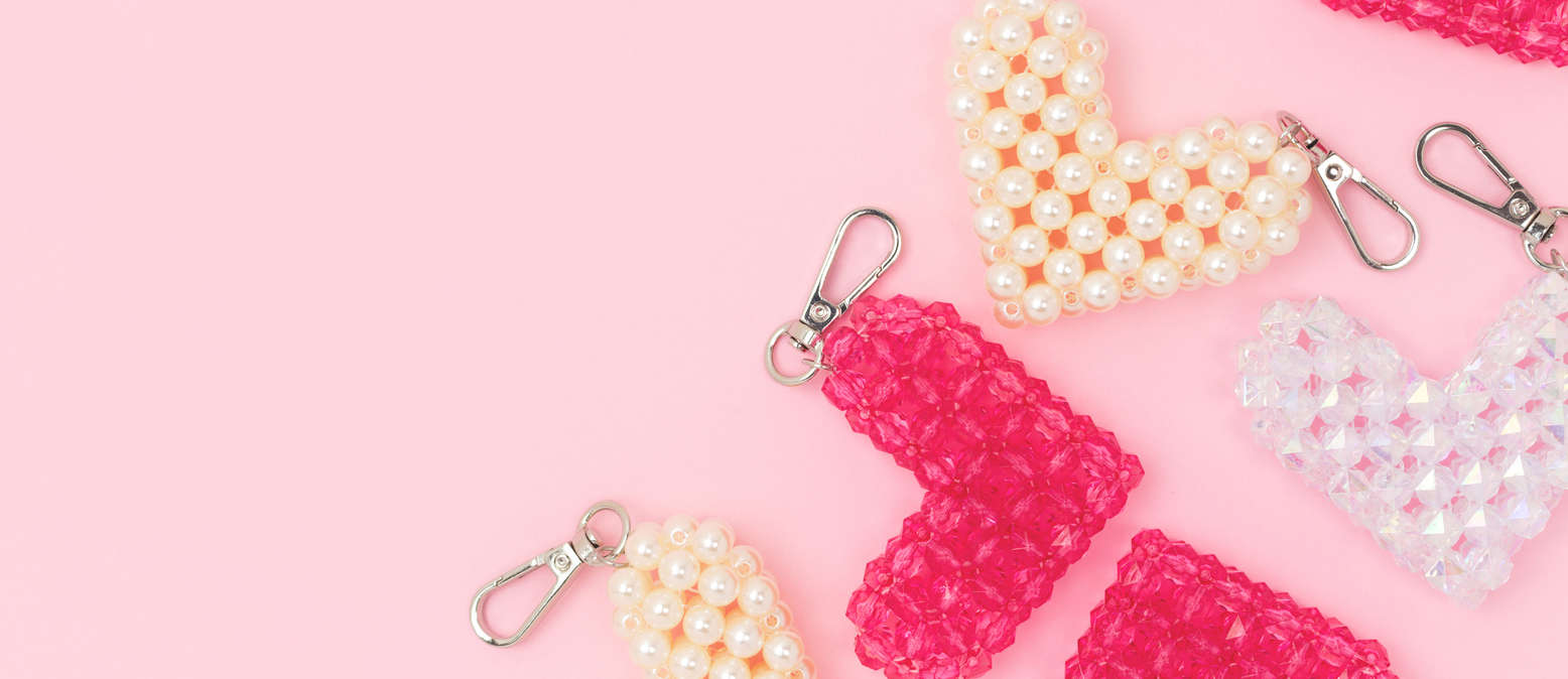 white pink and peach beaded handmade keyrings on a pink background