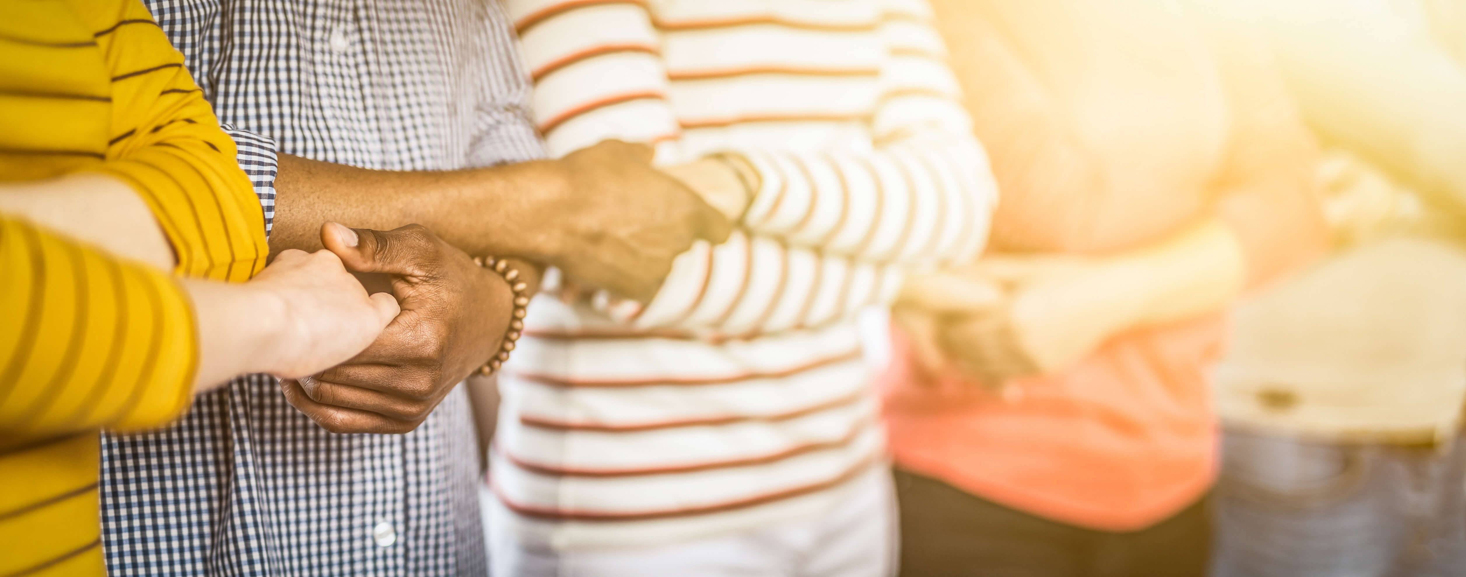 A group of people linking hands 