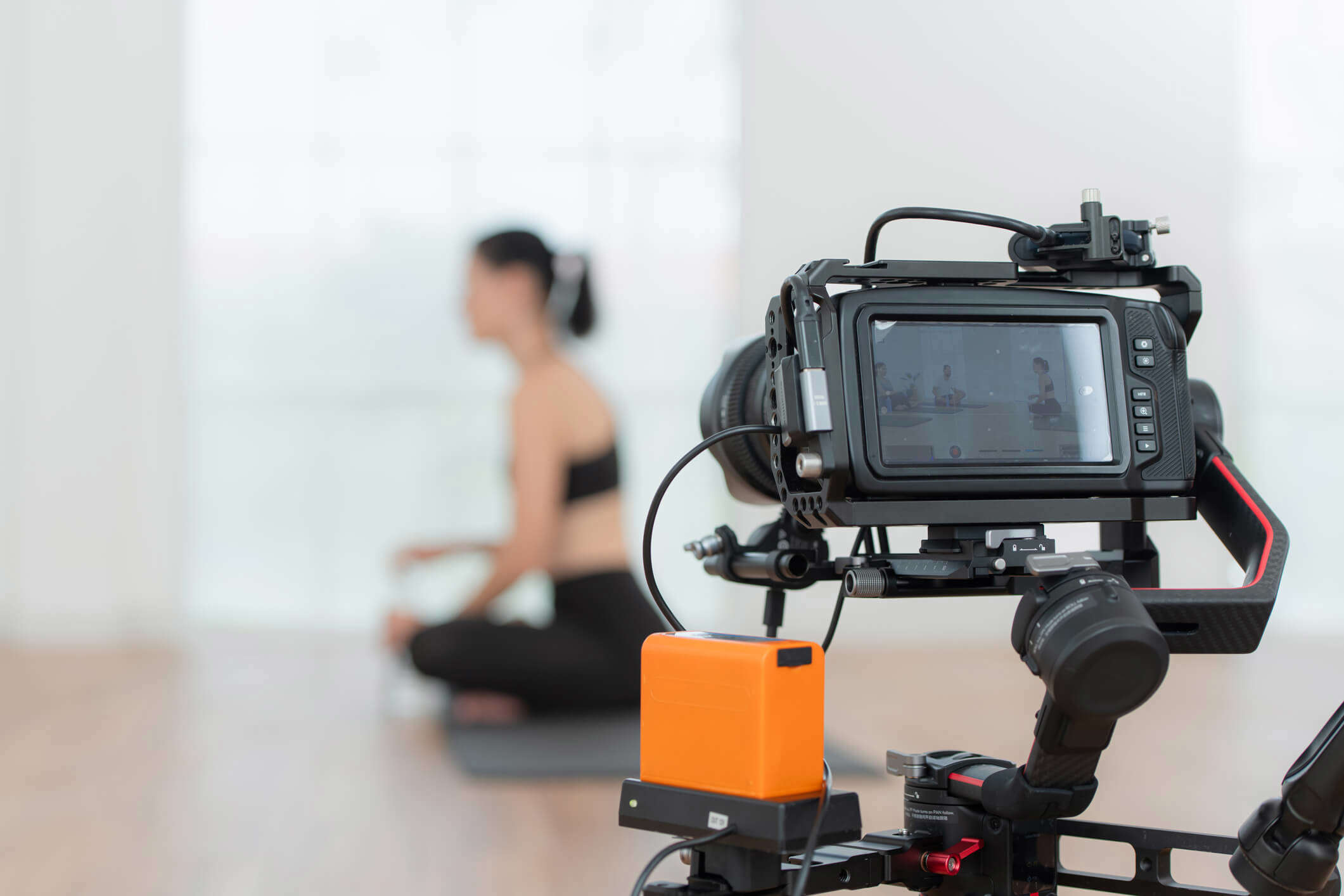 Someone being filmed holding a yoga class