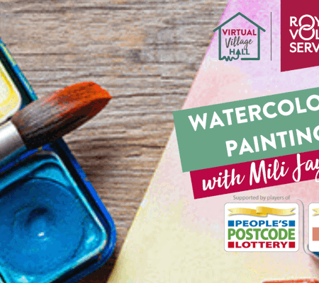 watercolour paint trays on a wooden table with a paintbrush resting on the case and canvas paper below