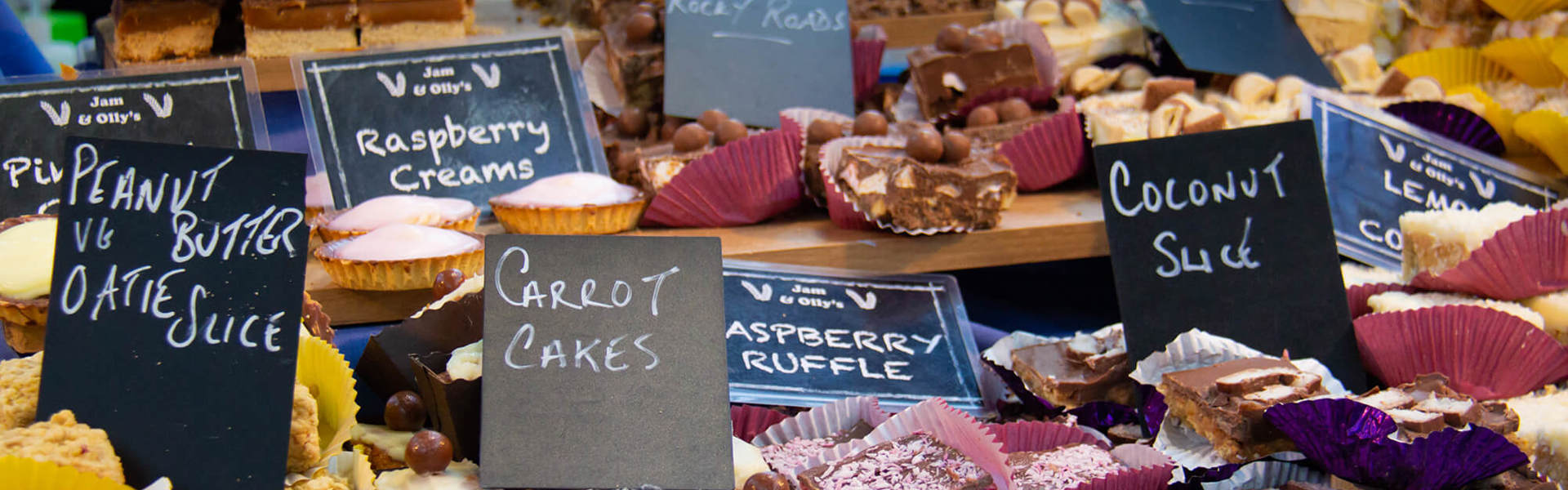 A countertop full of cakes and biscuits in a shop