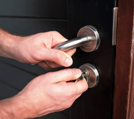 a person testing a lock on a black door