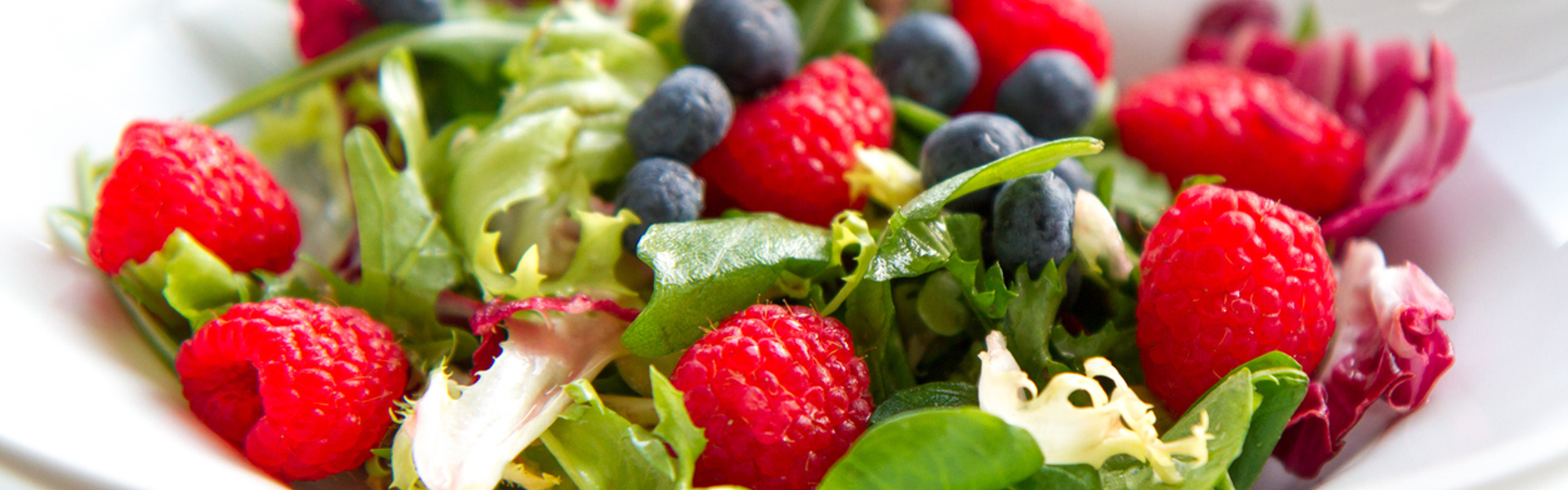 a fresh summer vegan salad with raspberries, blueberries and rocket salad leaves