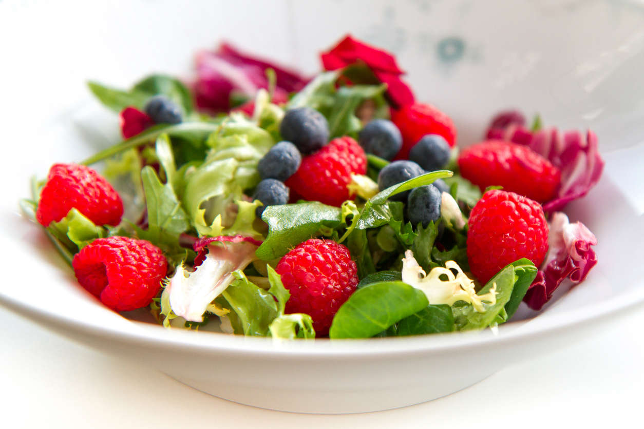 a fresh summer vegan salad with raspberries, blueberries and rocket salad leaves