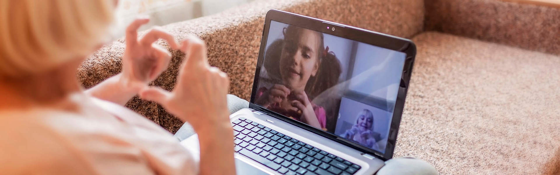 a grandmother facetiming with her granddaughter over a laptop