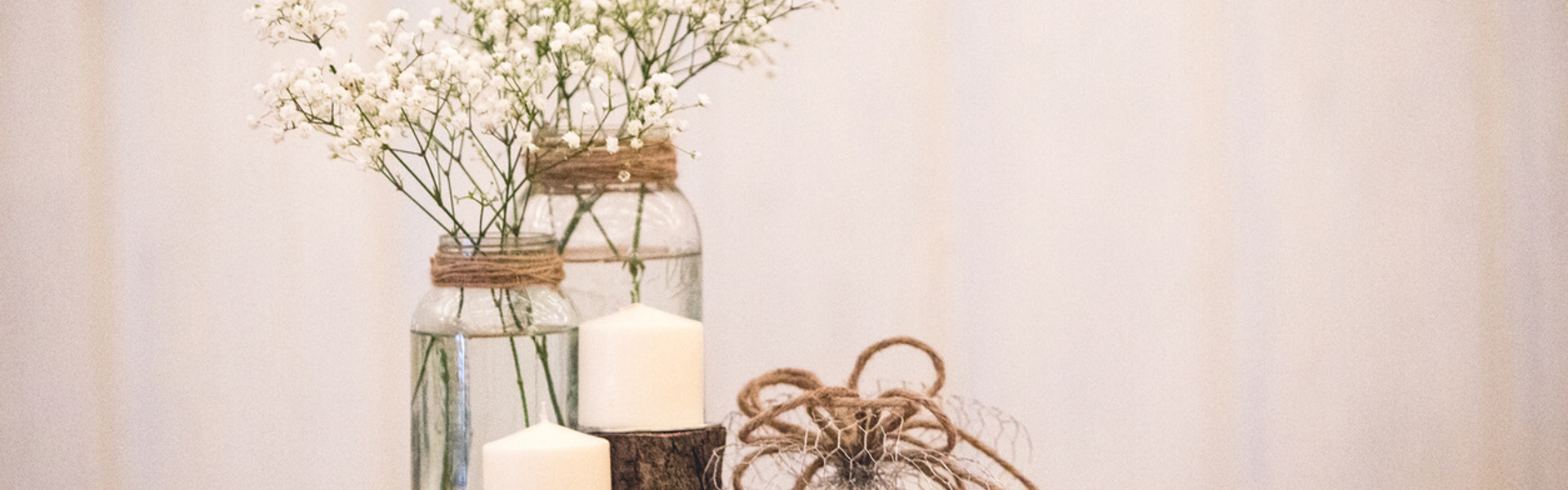 a DIY table centrepiece made from mason jars, string, wire, candles and a slab of wood 