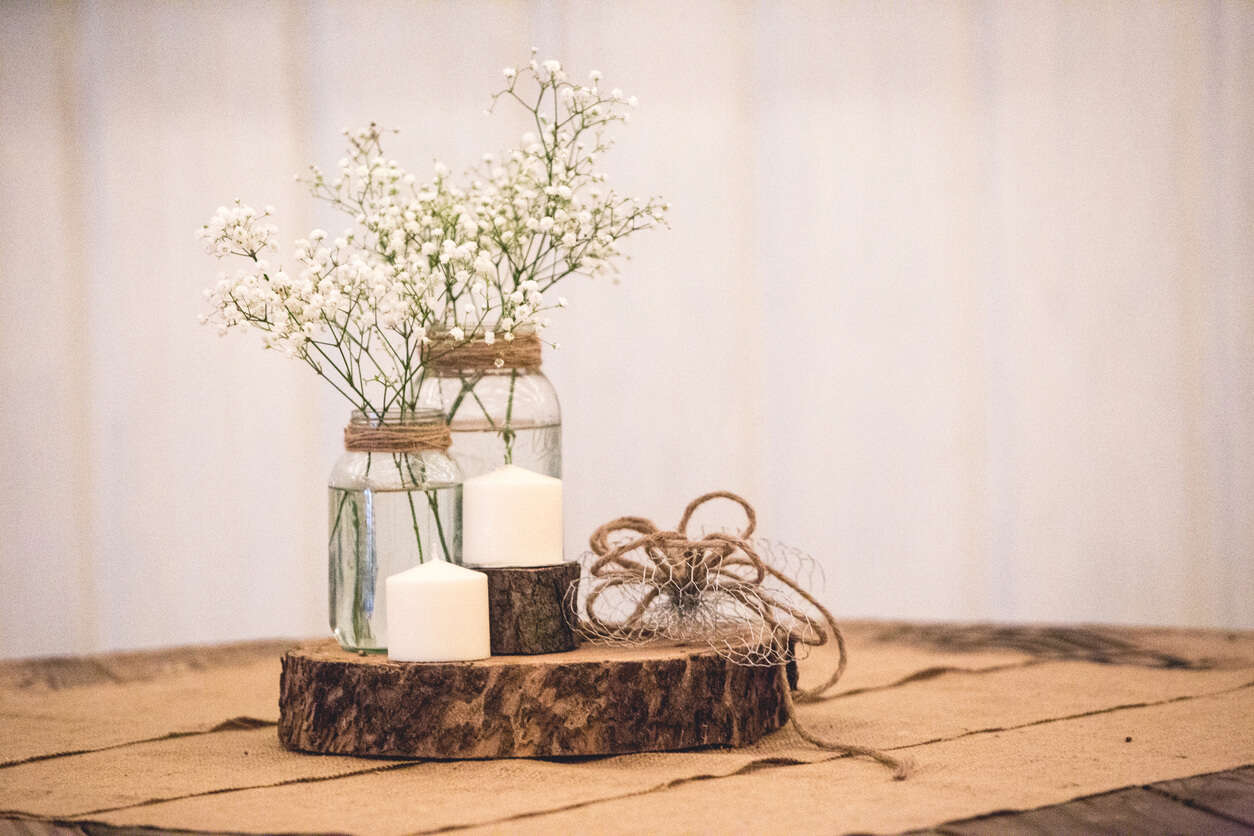 a DIY table centrepiece made from mason jars, string, wire, candles and a slab of wood 