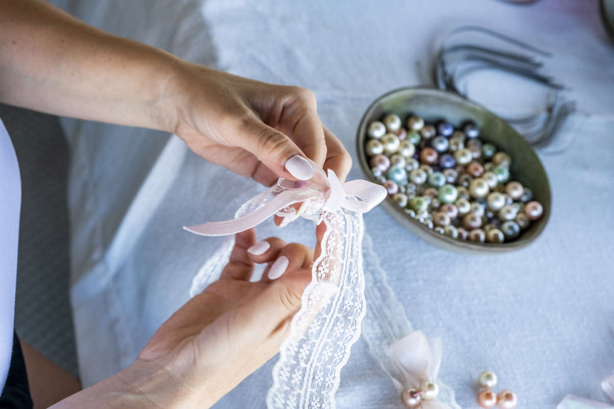 a close up of hands holding a pink and white lace DIY vintage key ring