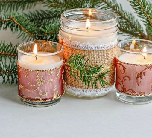 Main image: three homemade scented candles with festive ribbon and decoration.