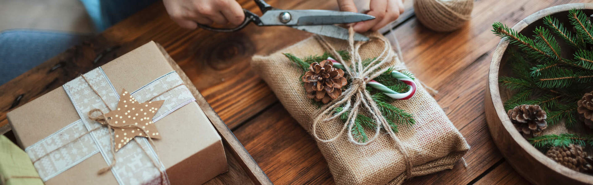 a person wrapping a Christmas gift using eco friendly recycled materials