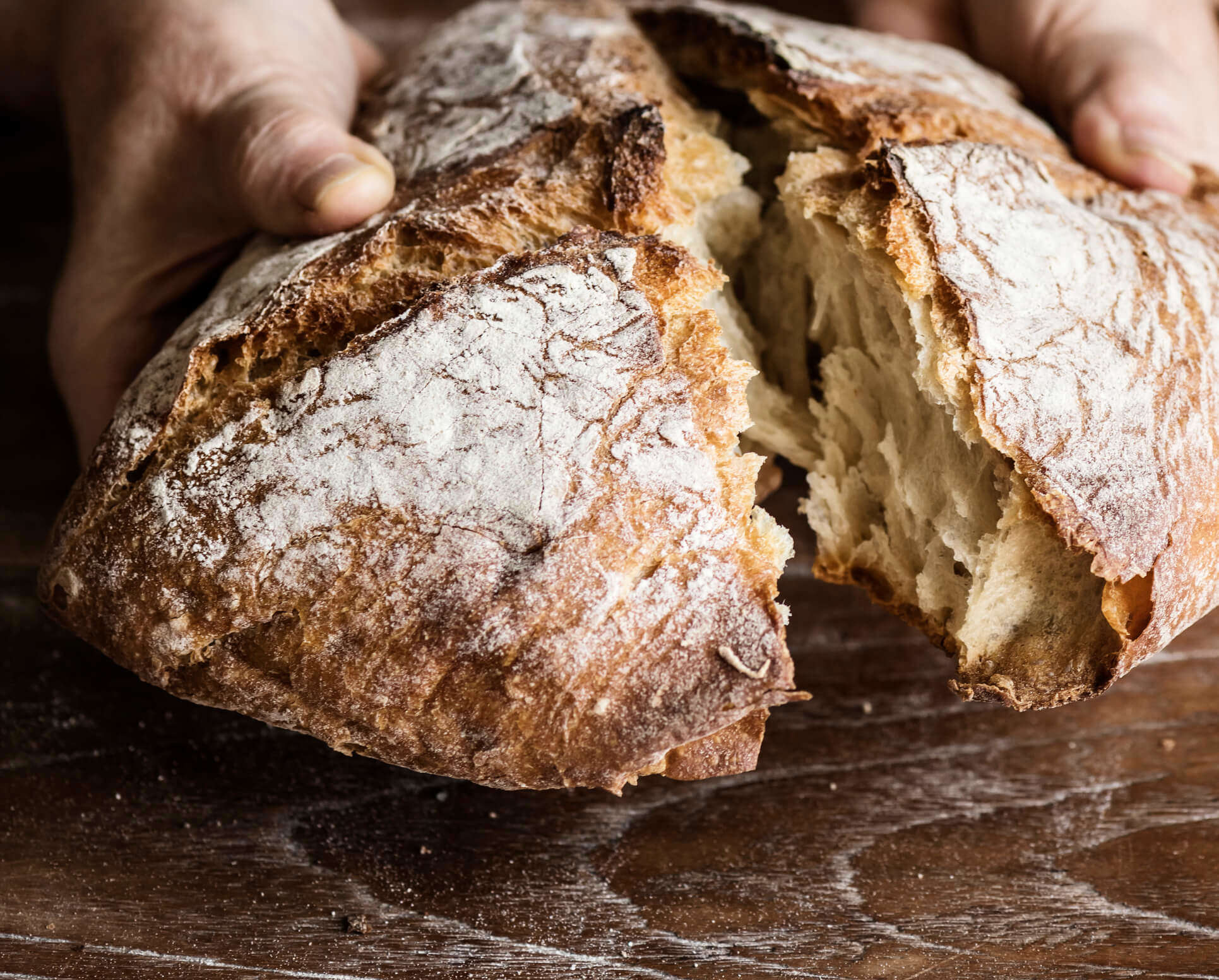 a freshly baked loaf of bread being broken open